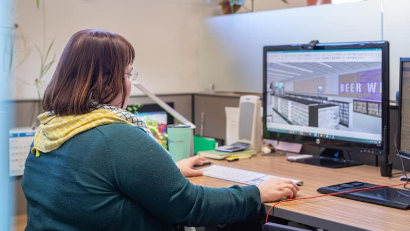 A KRS designer reviewing a 3D store model at her workstation