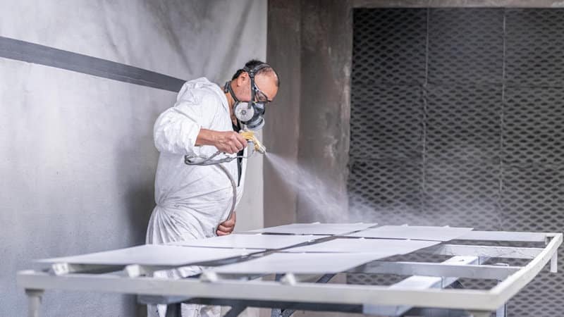 A KRS finisher spraying panels in the paint booth